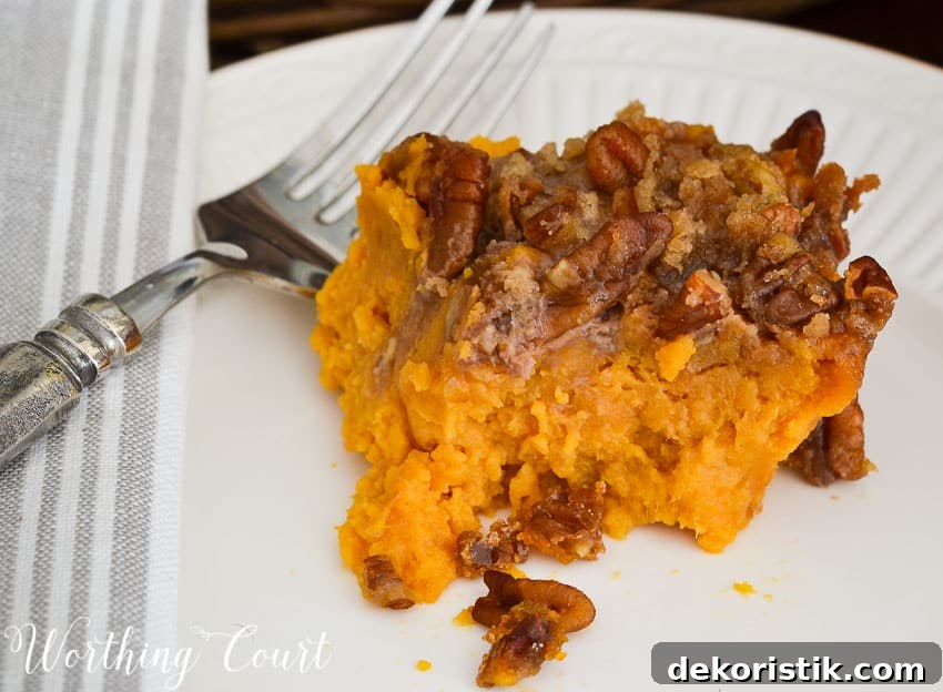 Sweet Potato Casserole with Brown Sugar Pecan Topping 5 Up close picture of the casserole on a white plate.