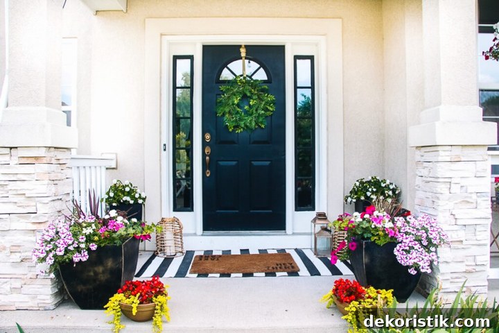 small front porch filled with pots of flowers on a white brick house with a black door