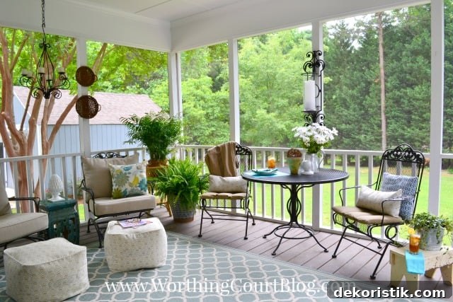 There is large trees and grass outside of the porch area.