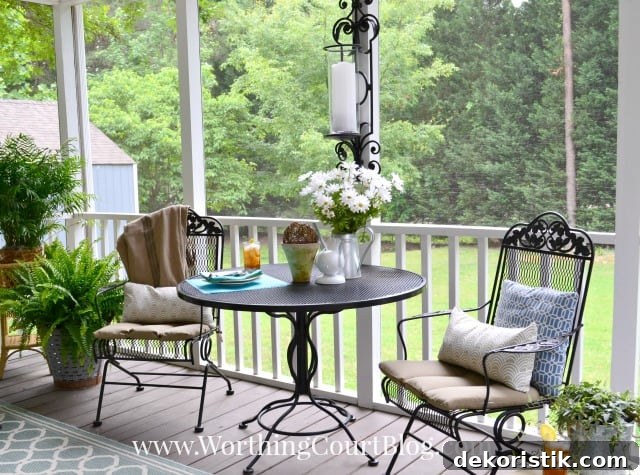 A small wrought iron table and chairs are on the porch.