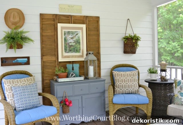 There are hanging plants on the side of the porch.