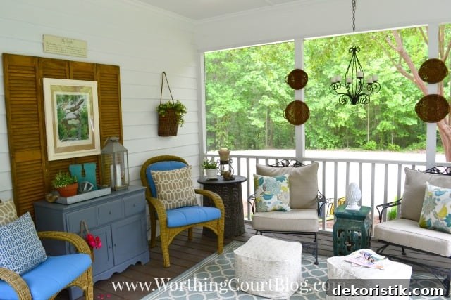 There is a rug in the middle of the porch with chairs around it.