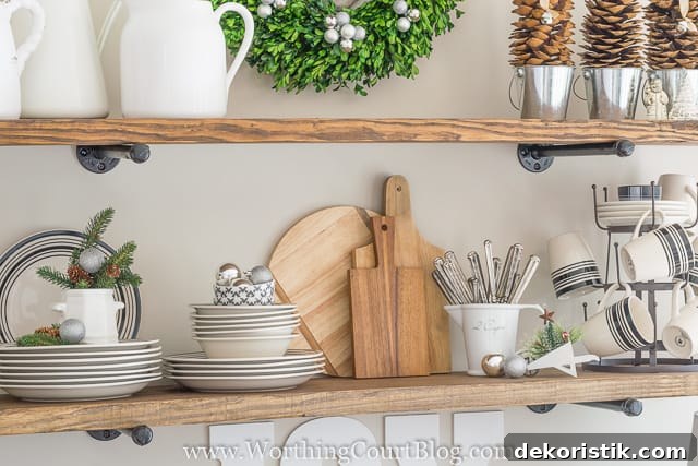 Dishes and cutlery are on the open shelves in the kitchen.