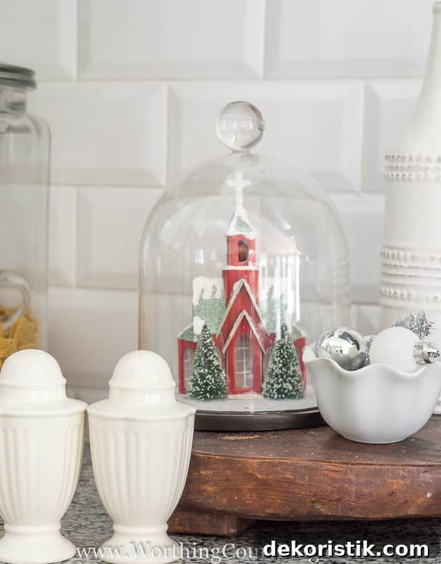 A cloche with a red church figurine underneath it.