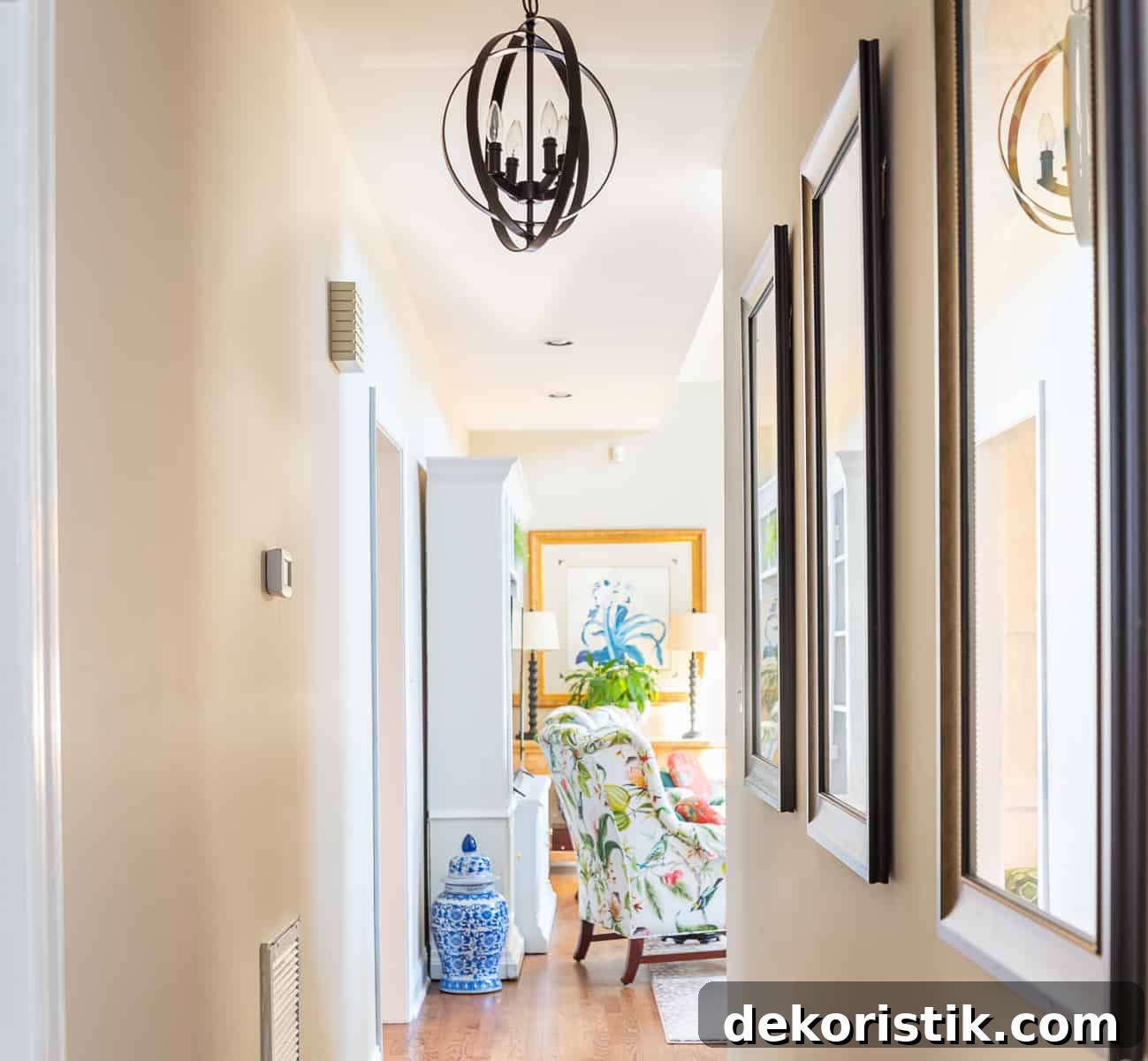 looking down a long hallway toward a living room with a colorful chair