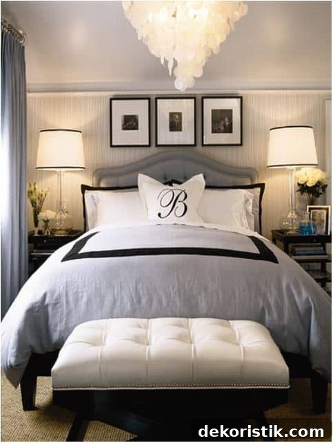 bed with gray, white and black bedding with a bench at the foot of the bed