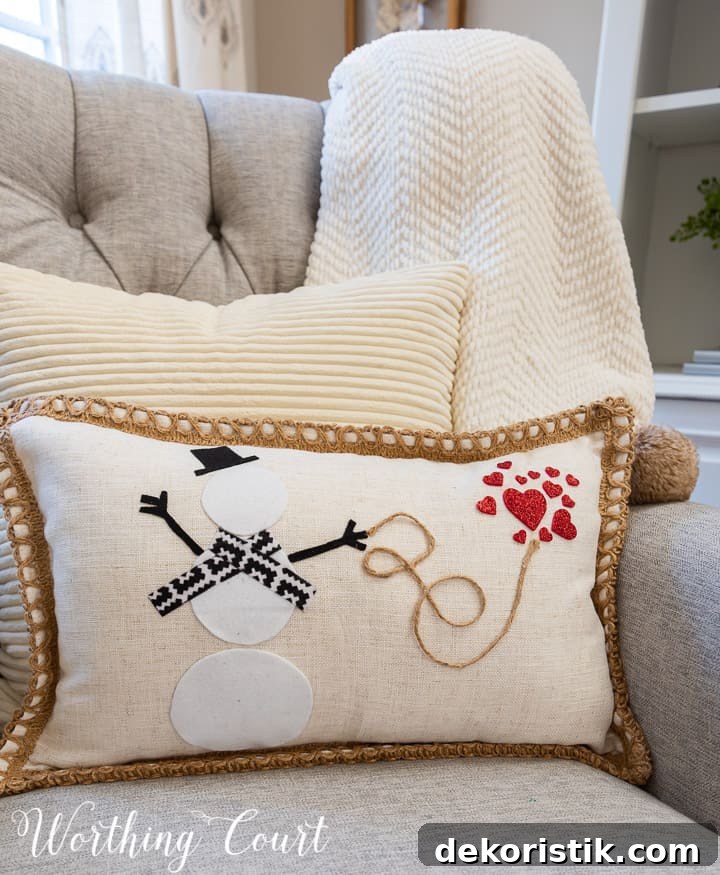 white pillow with felt snowman and hearts attached