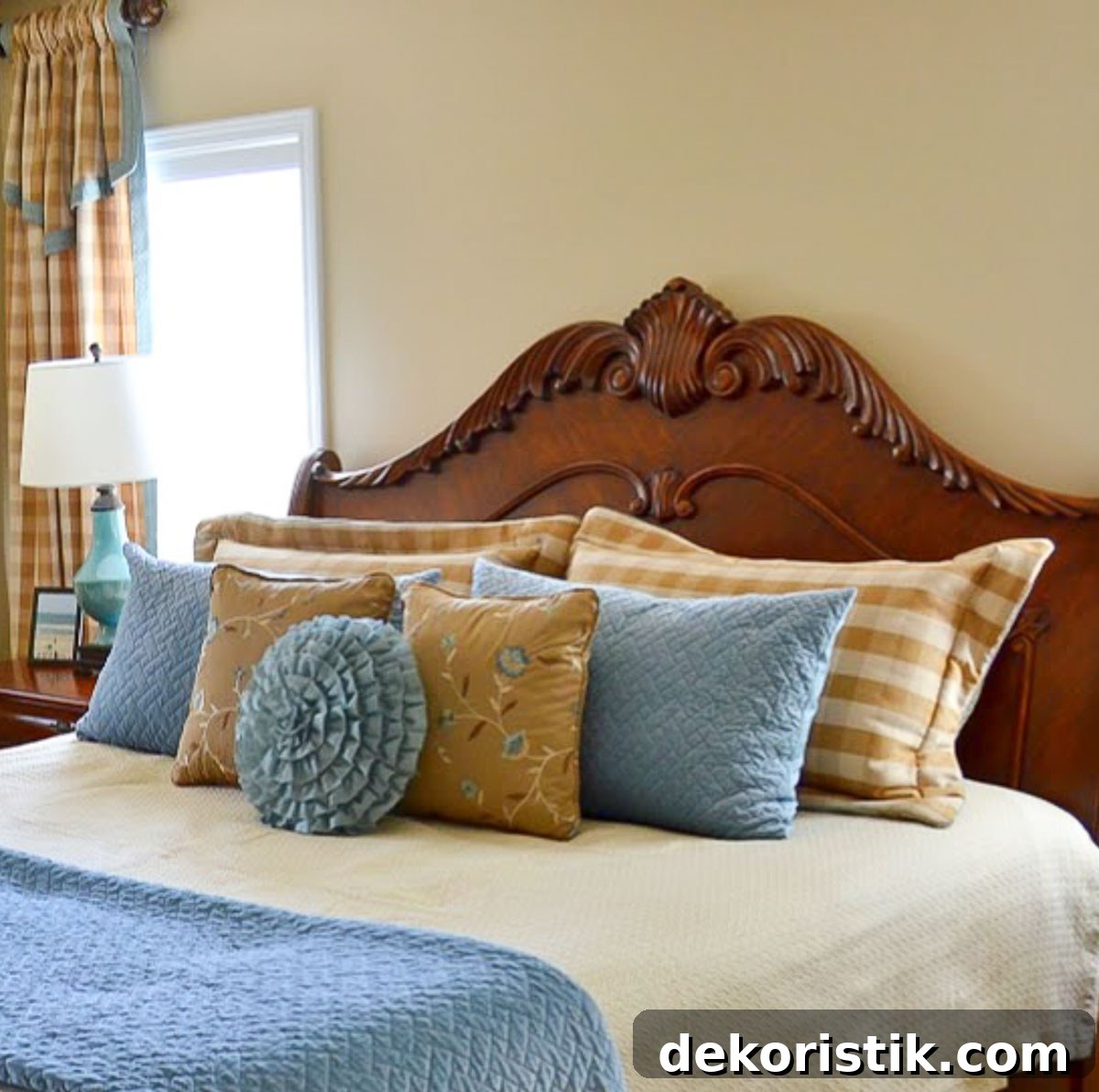 brown, cream and blue bed pillows and throw pillows on a king size bed with a wood headboard