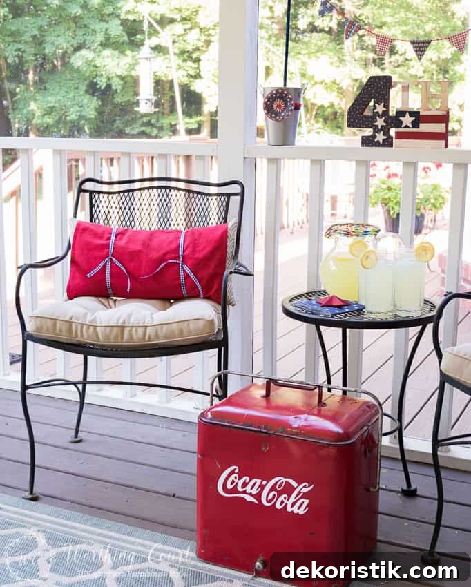 A farmhouse porch filled with loads of red, white and blue vintage Americana patriotic decorating ideas for Memorial Day, Flag Day and July 4th.
