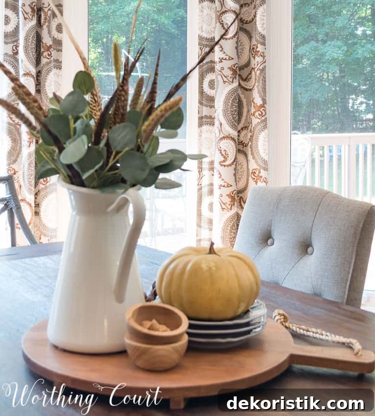 Small wooden bowls are beside the white pitcher on the dining room table.