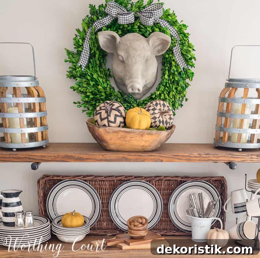 Herbert the pig has a wreath with a checkered bow around him and a dough bowl filled with fall items underneath on the shelves.