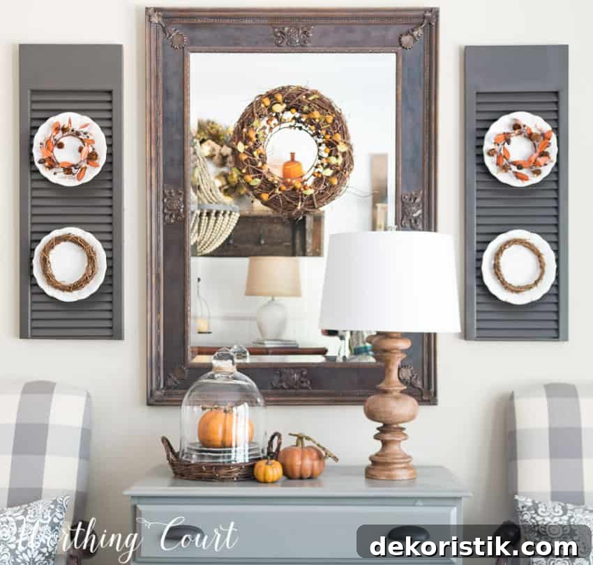Fall dining room mirror and shutters with plates that have fall decor.