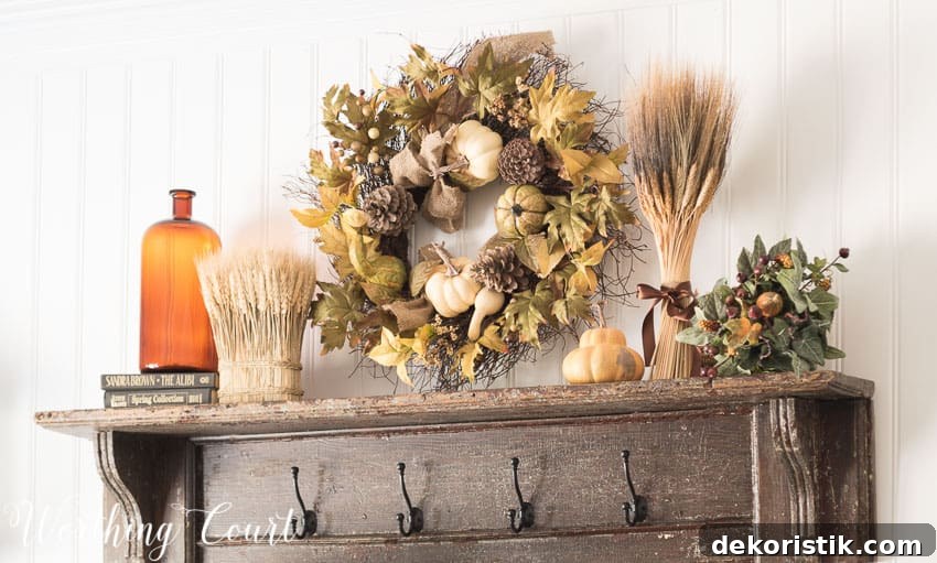 A wooden mantel shelf with a fall wreath above it, and amber glass on the shelf.