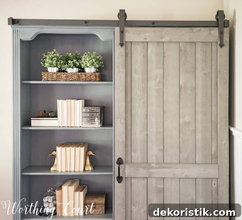 The open shelves on the bookcase with plants and books on them.