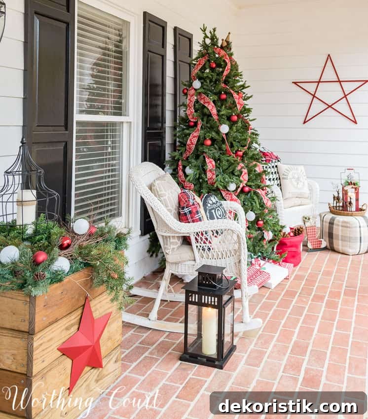 Front porch Christmas tree decorated with red ribbon.