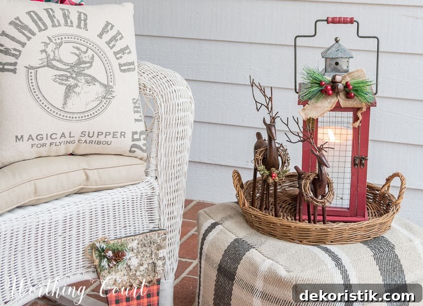 A white neutral reindeer pillow is on the wicker white chair.
