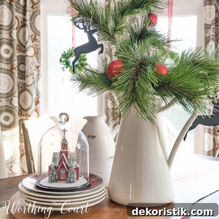 Farmhouse Christmas Breakfast Nook Decor Ideas 11 Farmhouse kitchen table Christmas centerpiece with a glass cloche and a white vase with greenery.