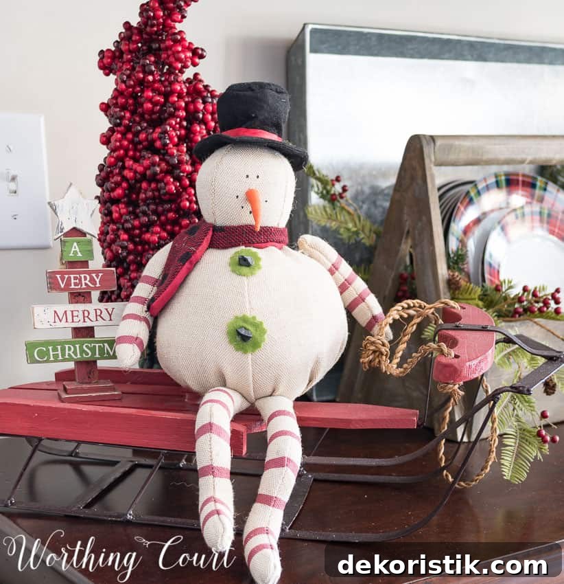 Farmhouse Christmas Breakfast Nook Decor Ideas 5 Christmas vignette with a primitive snowman and sled.