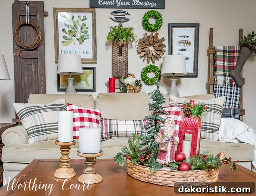 A small tray with a holiday vignette in it, plus white candles beside it.