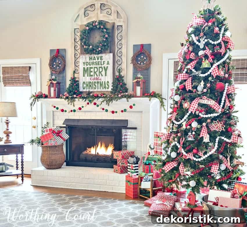 Festive Christmas colors on the mantel and a large Christmas tree beside the fireplace.