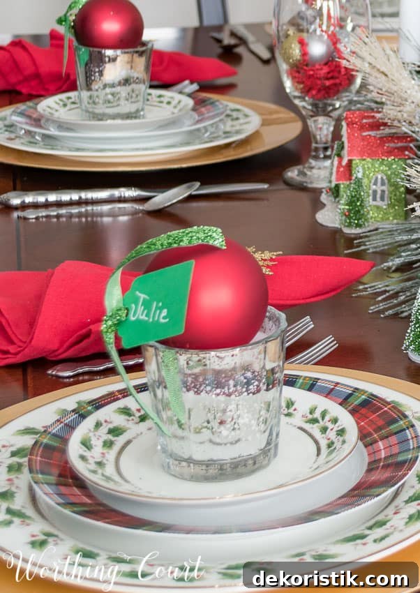 A red Christmas ornament holds the place setting card.