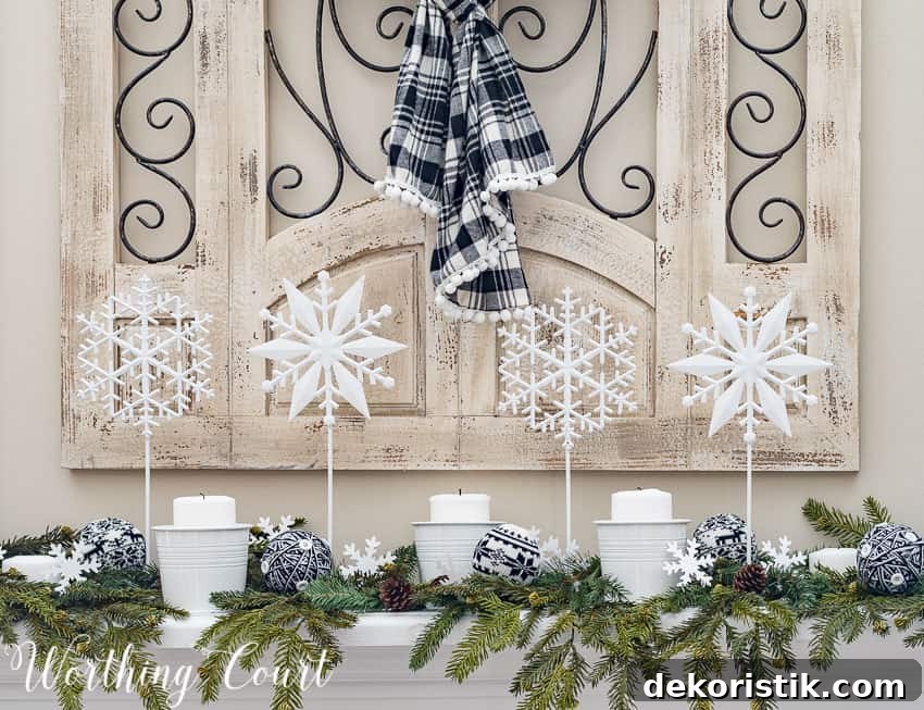 DIY snowflakes on a stick with candles and evergreen on the mantel.