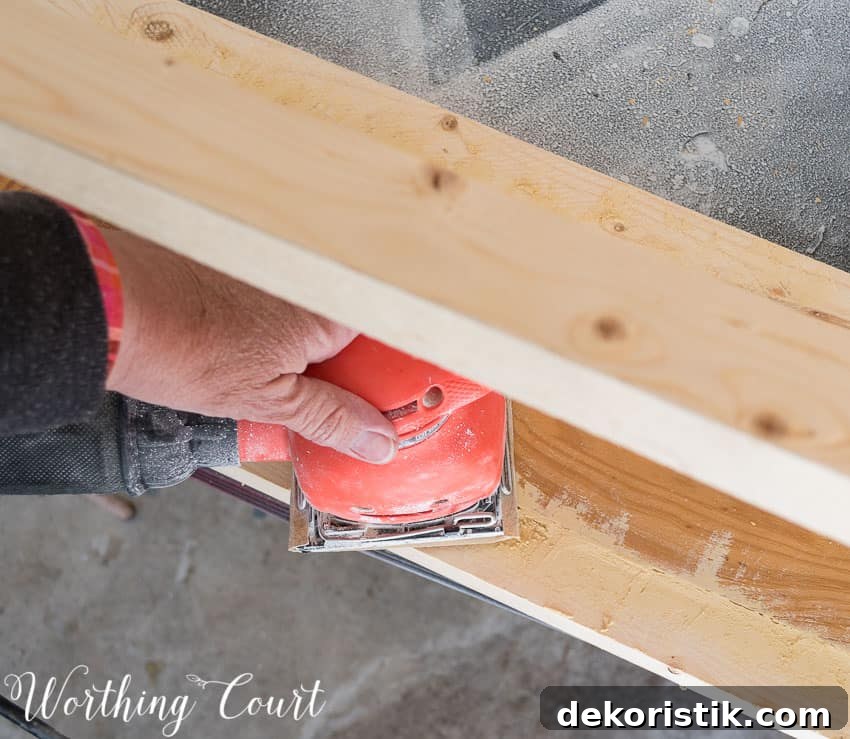  Using a hand sander on the base.