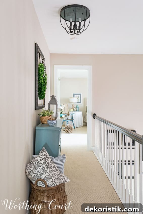 There is woven basket filled with throw pillows beside the chest of drawers in the hallway.