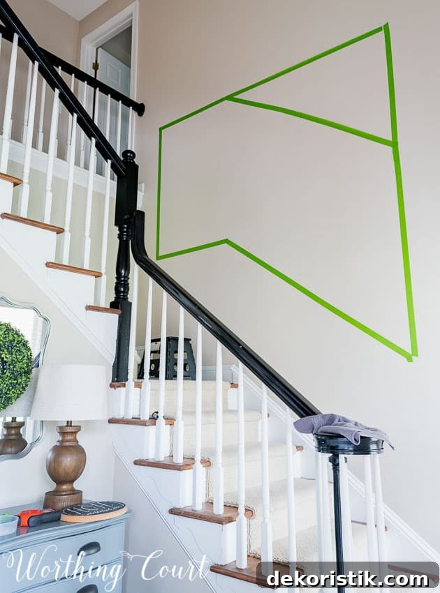 Gallery Wall Ideas for Staircases 4 The green painters tape on the wall mapping out the gallery wall.