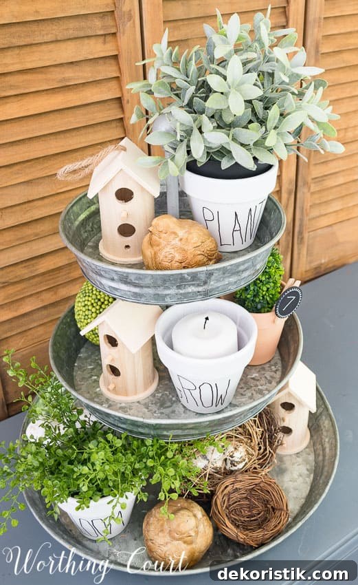 An aerial view of the tiered tray all decorated with the pots and birdhouses and bird nest.