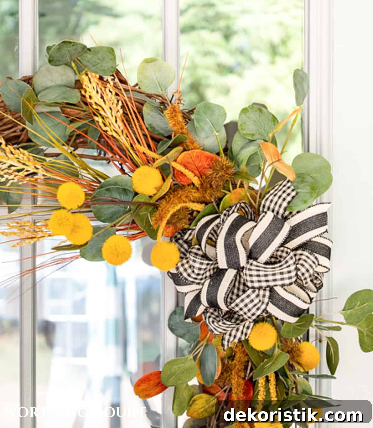 one corner of a diy fall wreath made with traditional fall colors and a black and white bow
