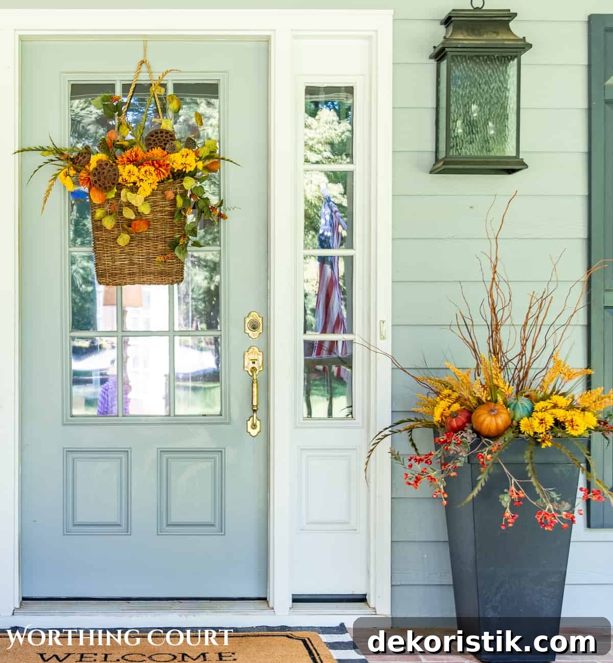 gray front door with hanging basket and planter filled with fall foliage