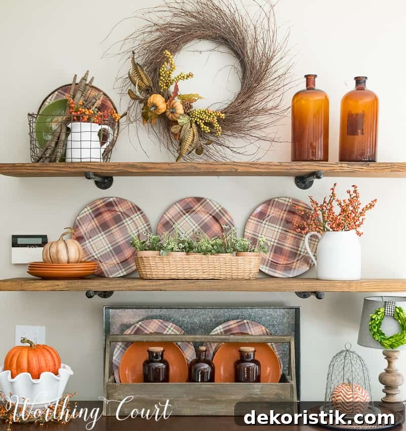 Open shelving with a fall wreath on the wall, plaid plates, and amber glass.