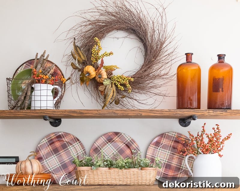 Rustic farmhouse open shelves decorated for fall with plaid plates, brown glass bottles and a grapevine wreath. 