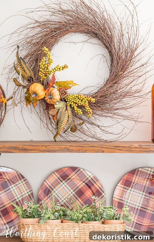 Make a super easy fall wreath by tucking a couple of faux floral bushes in between the stems of the wreath. Done in 5 minutes! This wreath is on the wall by the shelves.