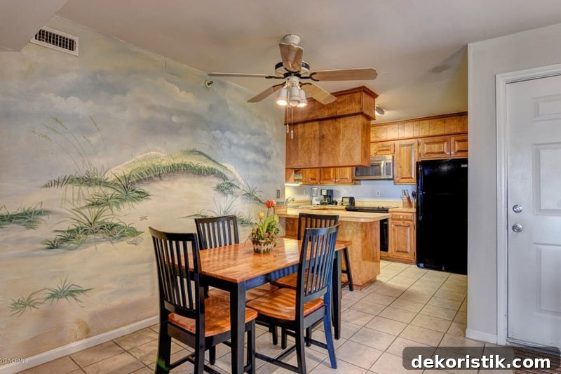 Dining Room with a small wooden table, a mural on the wall and an old fan/light above the table.