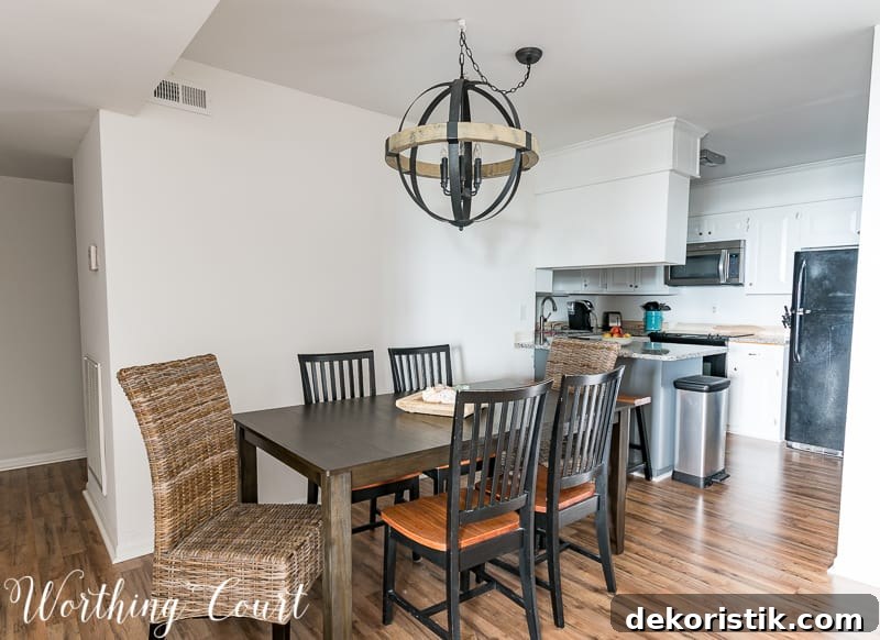The walls painted white with a larger table in the dining room and the orb light hanging above it.