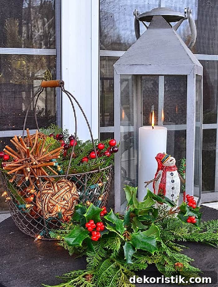 Christmas vignette with lantern, mini snowman, wire basket with orbs and faux greenery