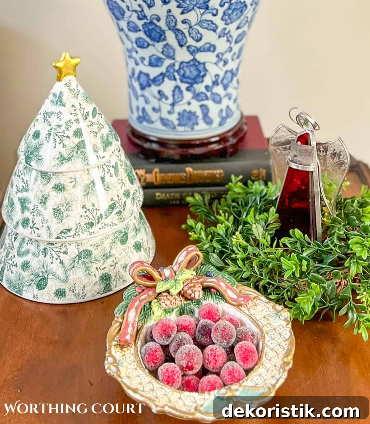 Angel, ceramic Christmas tree and bowl of red berries on a wood end table for Christmas