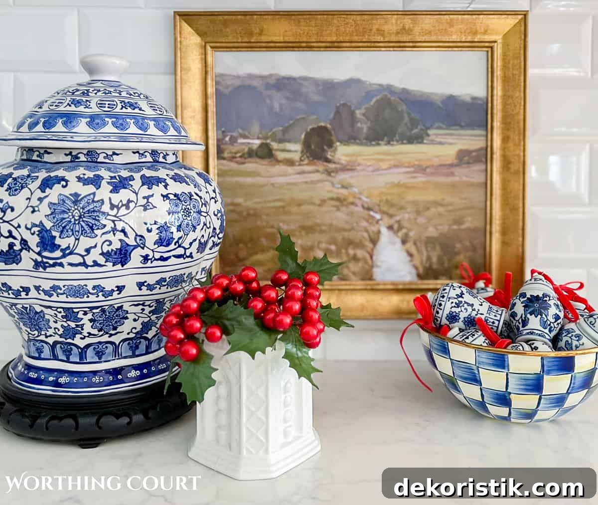 Christmas vignette on a kitchen counter with blue and white accessories and red berries in a small vase