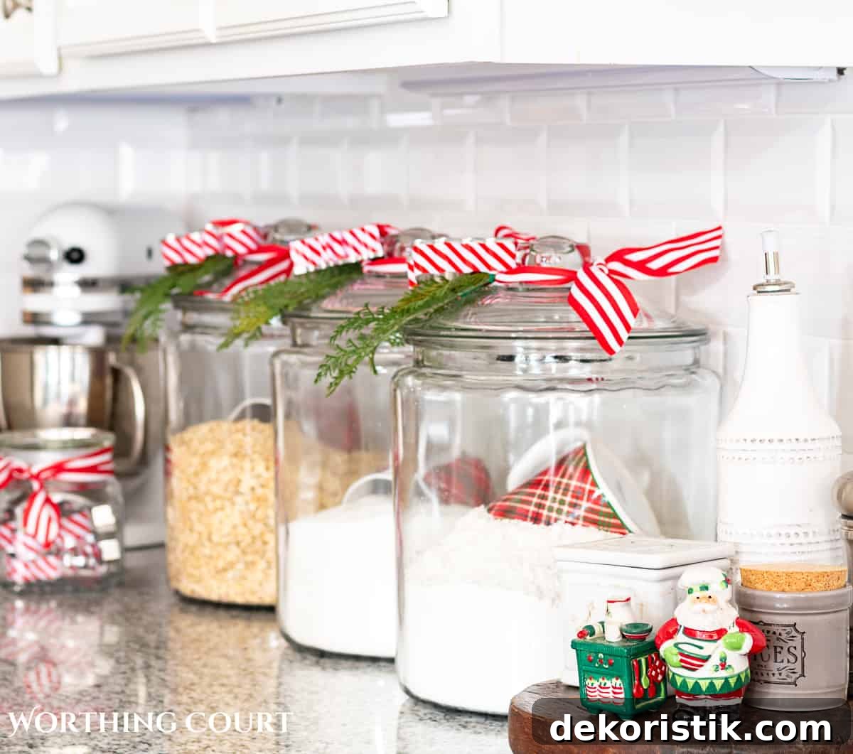 clear glass canisters with red and white striped ribbon and faux Christmas greenery tied to the top