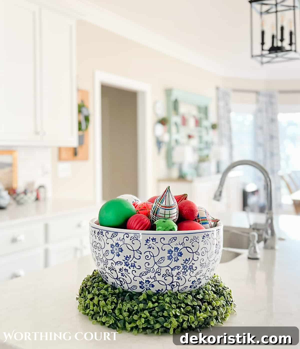 large blue and white bowl filled with red, green and blue Christmas ornaments on a kitchen island
