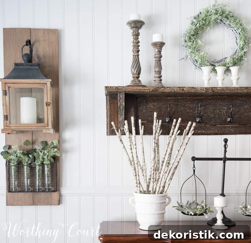 Winter farmhouse dining room decor with candles decorating the sideboard and a wooden shelf with candlesticks on it.