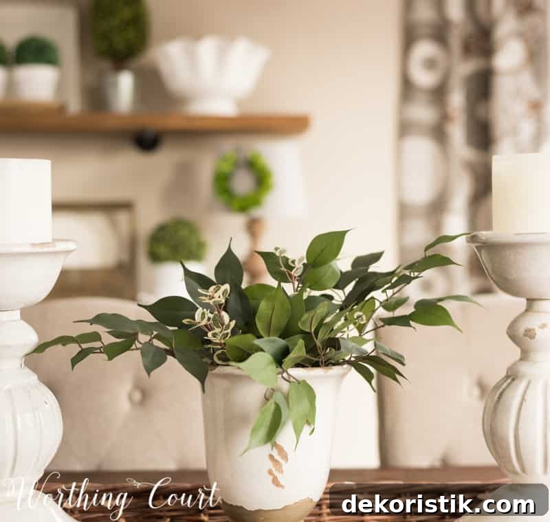 A white piece of pottery with green leaves in it.