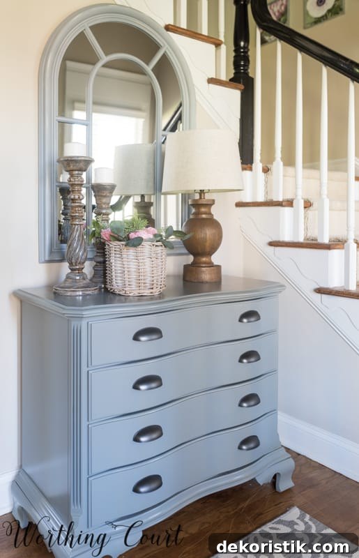 Entryway Makeover Reveal: DIY Ideas Using What You Have 17 The chest in the foyer with a lamp and a candlestick on top.