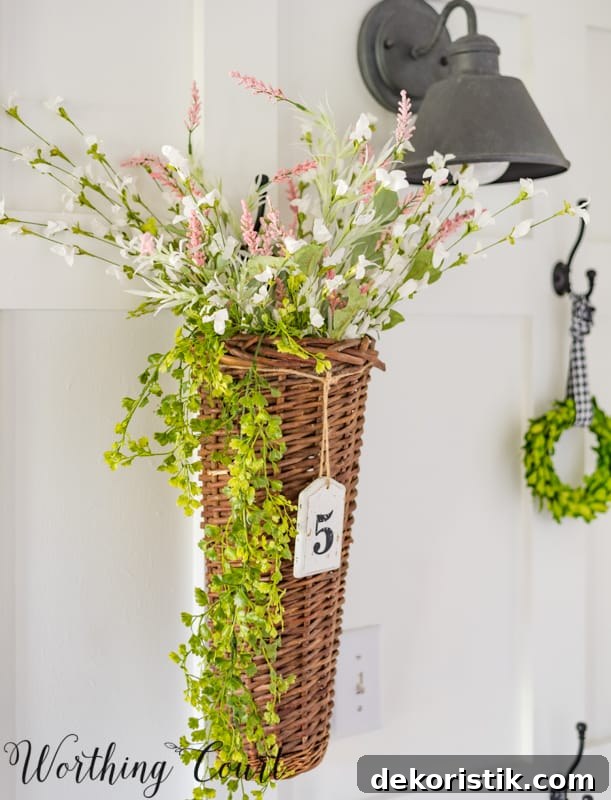 Entryway Makeover Reveal: DIY Ideas Using What You Have 19 A small basket hanging on the wall is filled with flowers.