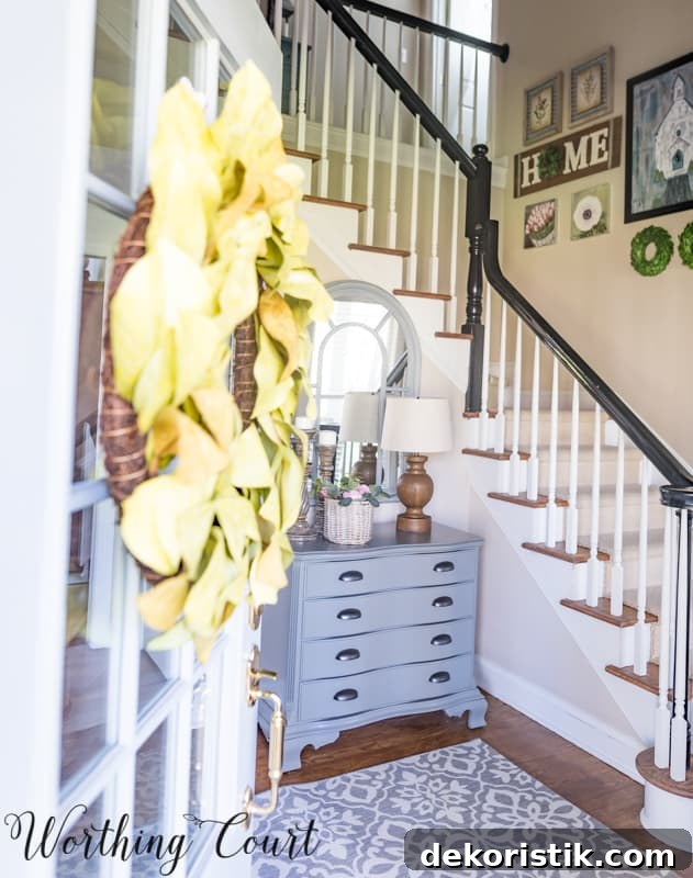 Entryway Makeover Reveal: DIY Ideas Using What You Have 7 A small table with drawers and a lamp just inside the door.