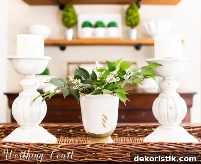 white room accessories and dining table centerpiece with white candlesticks and white vase filled with greenery in a wicker tray basket