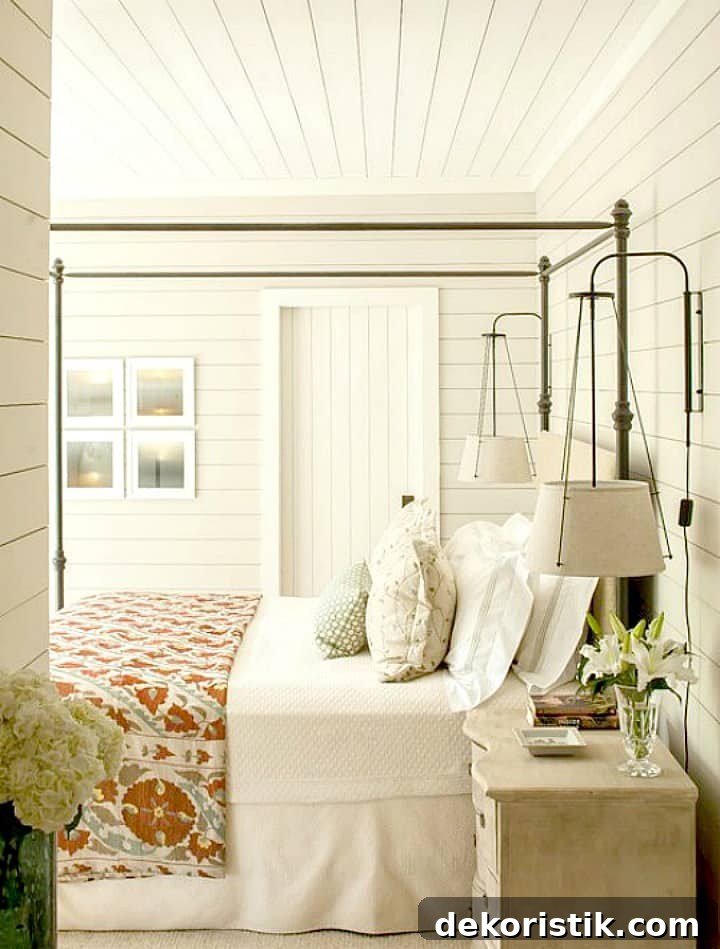 How to decorate a fixer upper farmhouse bedroom with white shiplap walls with metal bed and quilt and end table lights