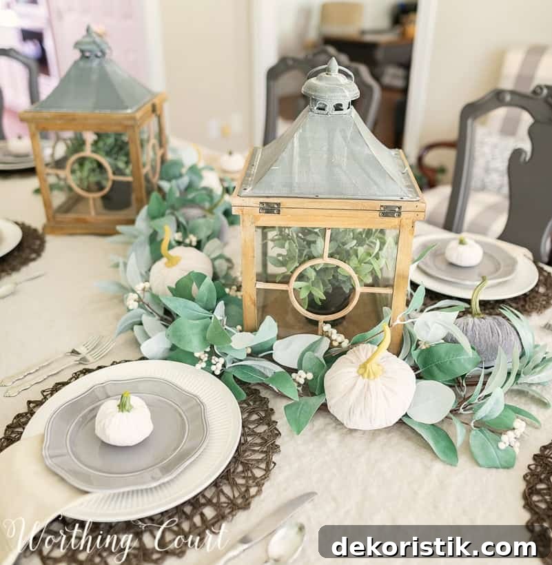 Fall centerpiece with lanterns and eucalyptus garland.